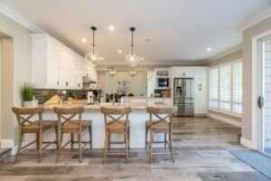 Bright white kitchen with large island and wooden bar stools