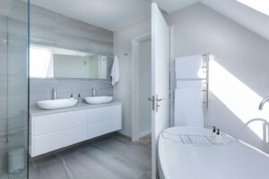Sleek gray bathroom with double vessel sinks and glass shower