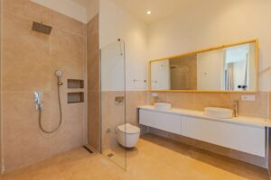 Modern beige tiled bathroom with double vessel sinks