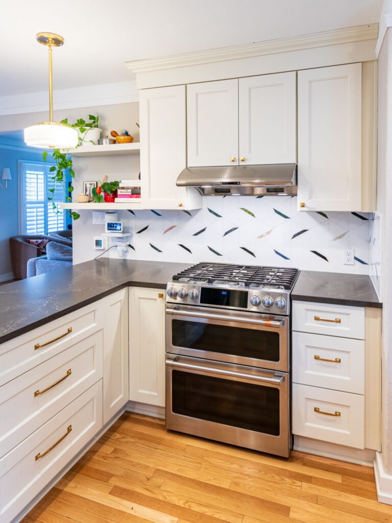 White kitchen corner with dark counters and gold hardware
